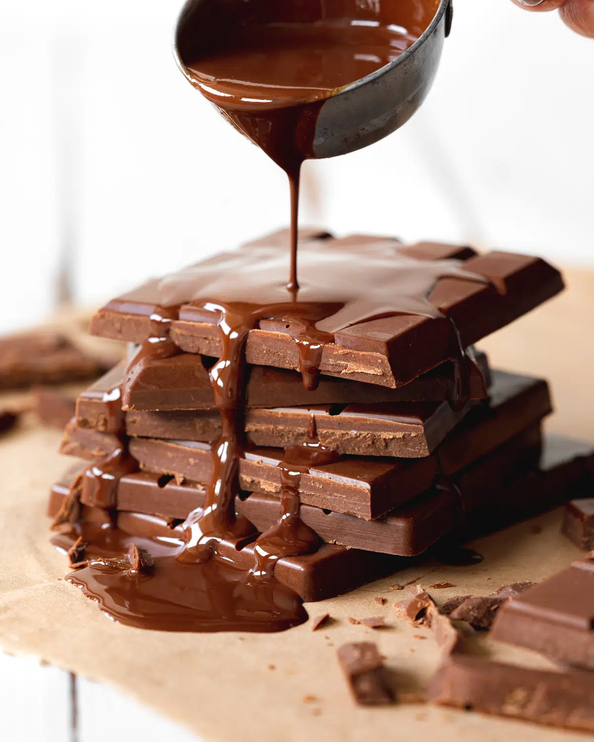 stack of vegan chocolate bars with melted chocolate pouring over them.