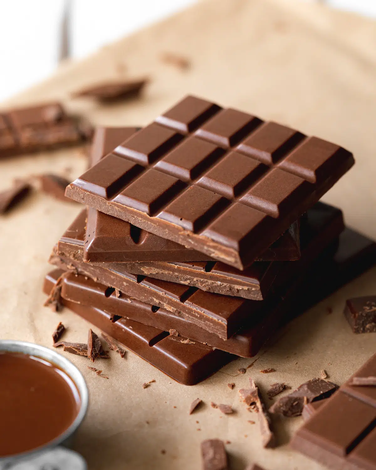 bars of dairy free chocolate stacked on top of each other on brown paper.