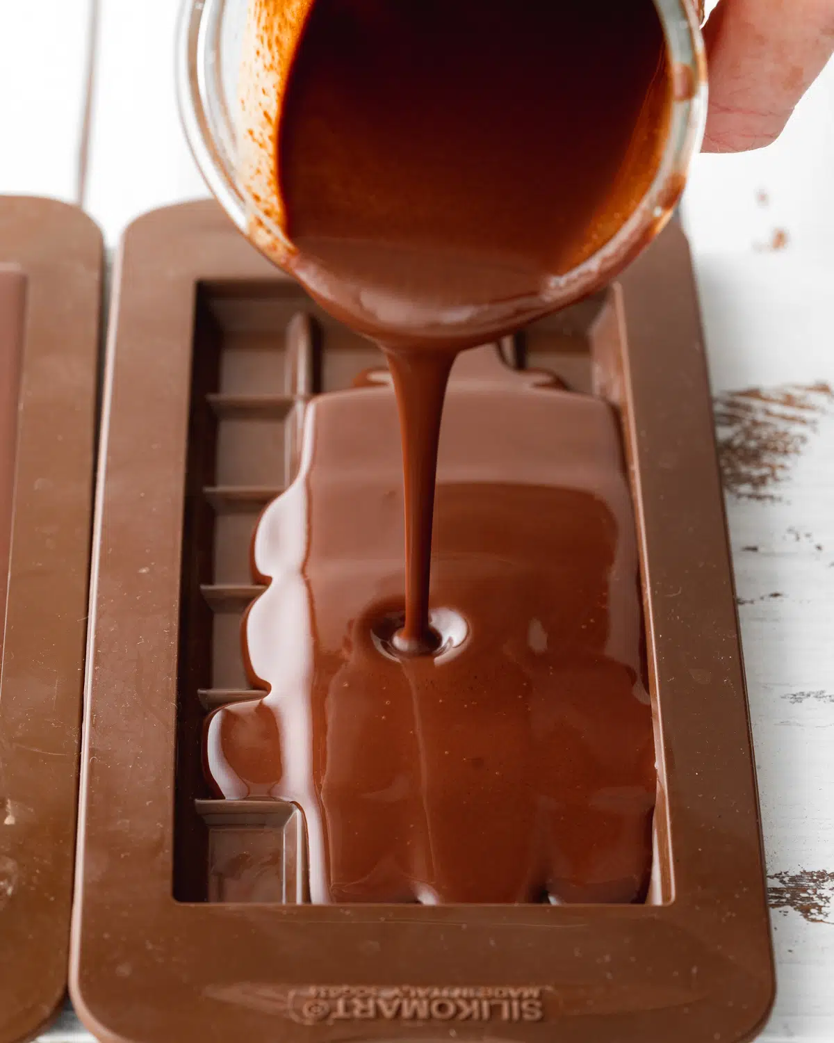 pouring chocolate into silicone moulds.