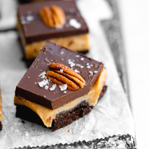 close up of salted caramel brownies with chocolate and pecans.