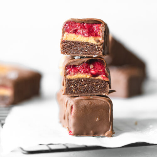 stack of peanut butter jelly filled chocolate bars on cooling rack.