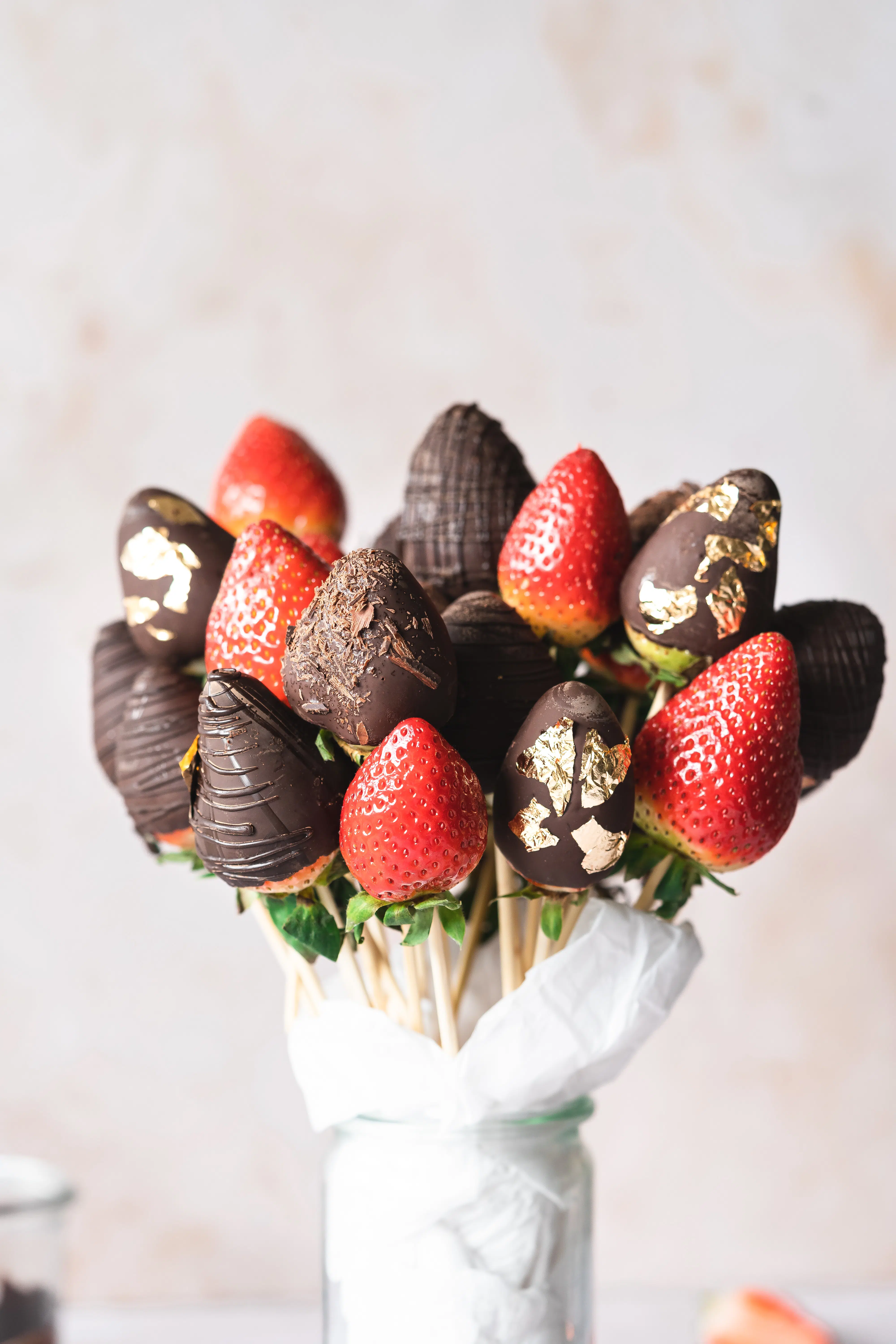 chocolate strawberry bouquet in a jar with crepe paper around them.