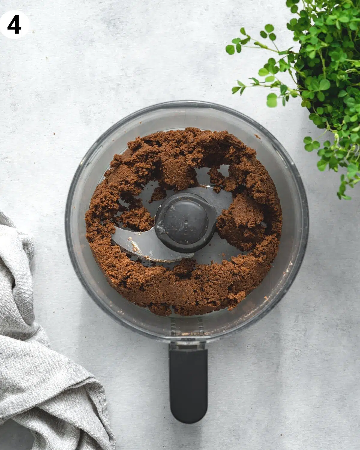 top down view of chocolate cookie crust in a food processor.