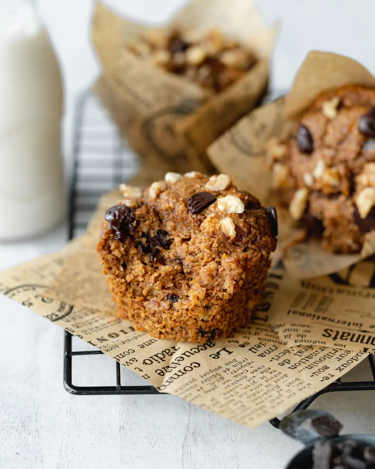 moist vegan banana muffins with chocolate chips on newspaper.