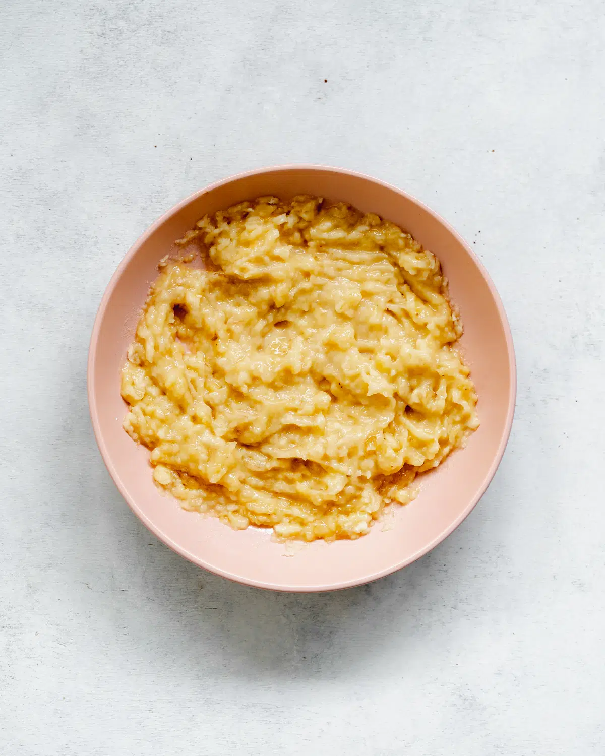 mashed banana in a pink bowl.