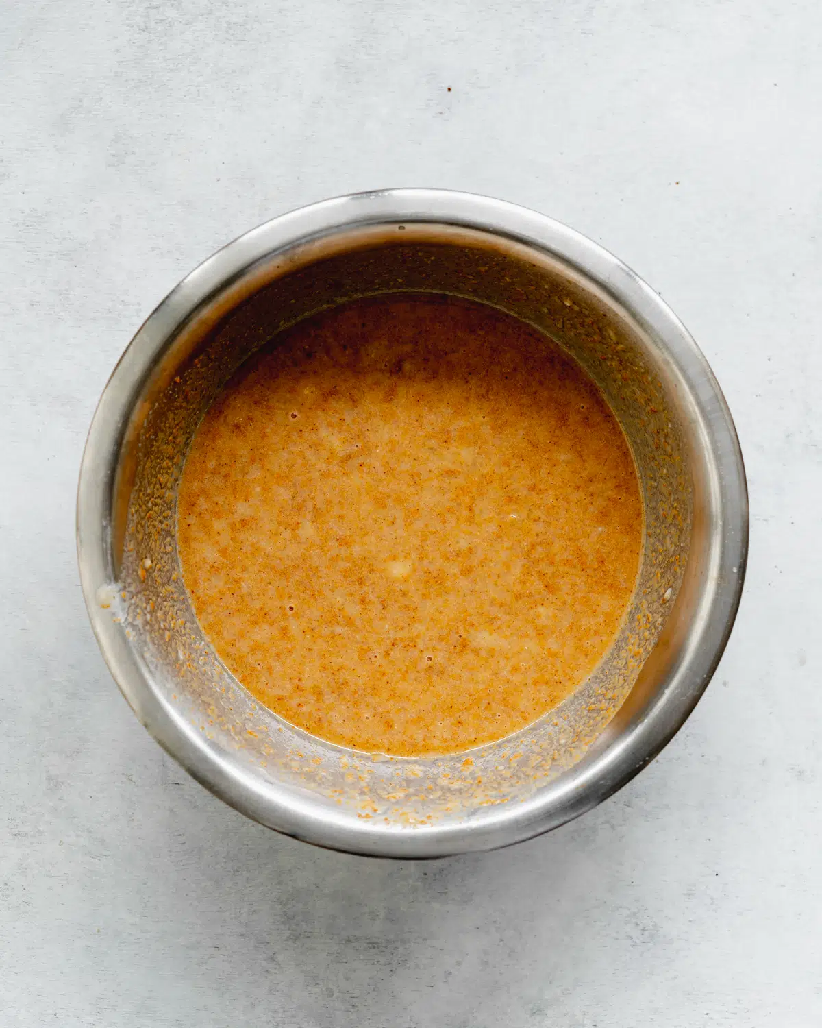 wet ingredients for gluten free peanut butter banana muffins in a bowl.