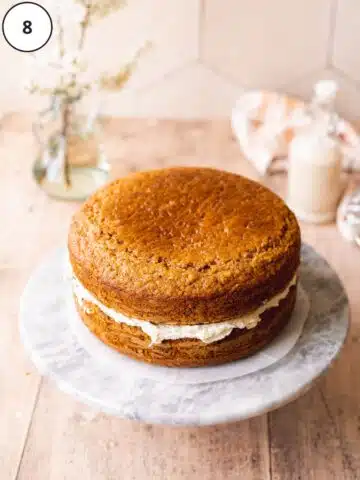 vegan carrot sandwich cake on a marble turntable.