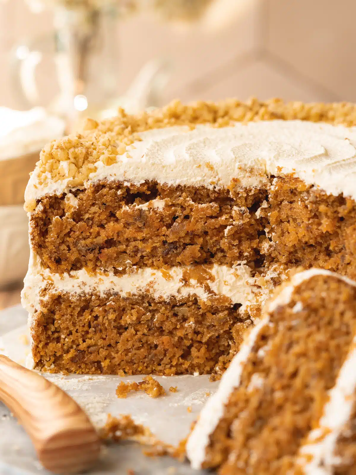 angle shot of a double layer vegan carrot cake with cream cheese frosting showing the fluffy consistency.