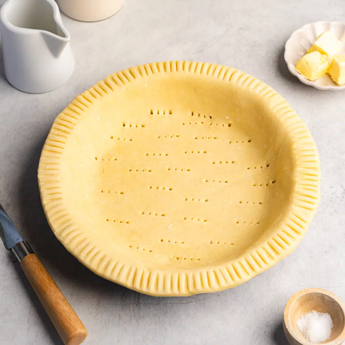 a flaky vegan pie crust in a pie tin before baking.