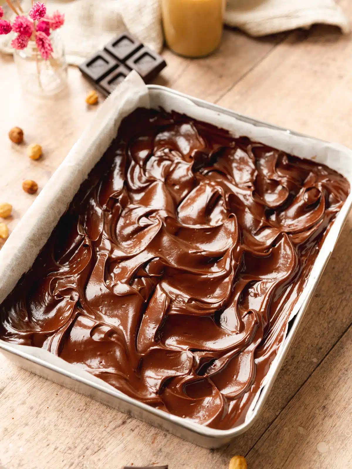 a tray with raw brownies and swirled chocolate ganache on top.