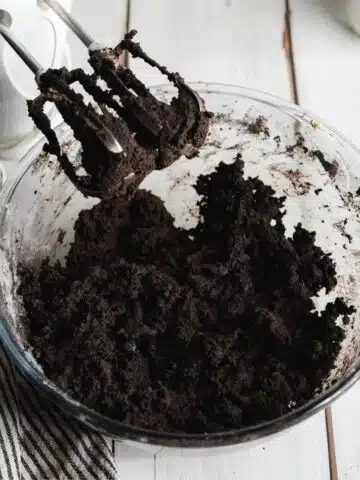 oreo cookie dough whisked with an electric mixer in a bowl.