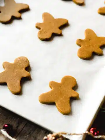 gingerbread cookies on a parchment-lined baking sheet before baking.