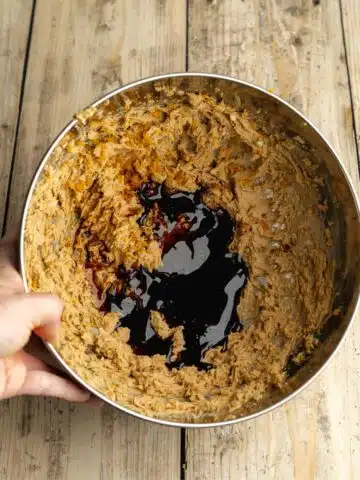 molasses, orange zest, and vanilla added to creamed butter and brown sugar in a mixing bowl.