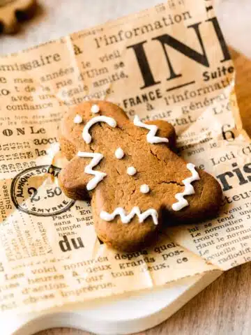 gingerbread cookie with royal icing on a sheet of newspaper.